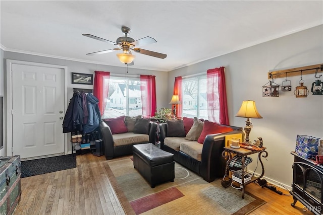 living room with wood-type flooring, ornamental molding, and ceiling fan