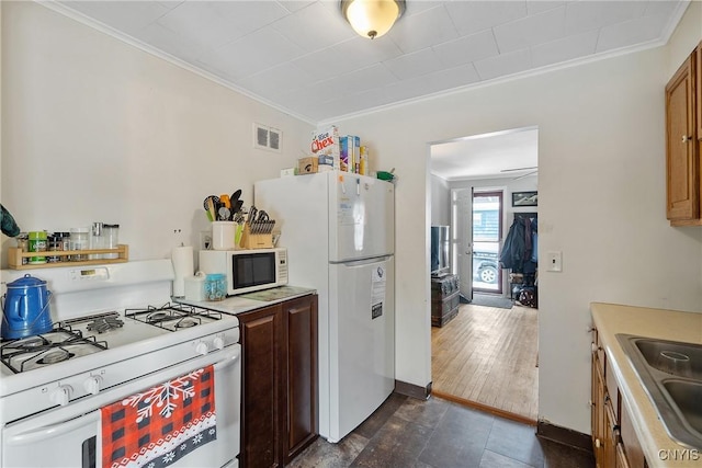 kitchen with sink, white appliances, and ornamental molding