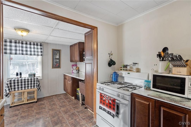 kitchen featuring white appliances, ornamental molding, and a paneled ceiling