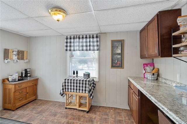 kitchen featuring a paneled ceiling and wooden walls