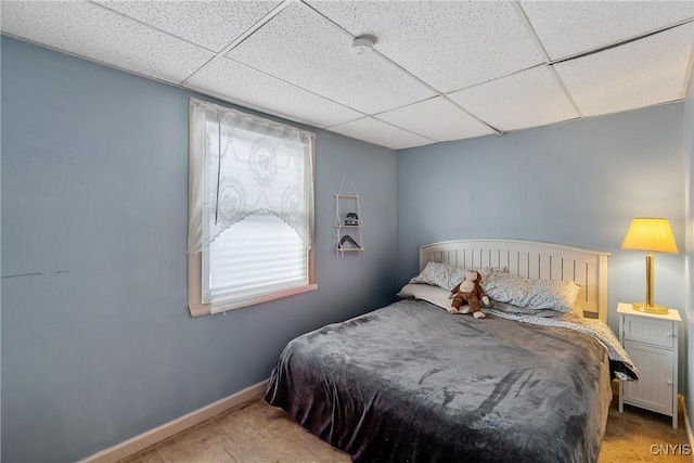 bedroom featuring a paneled ceiling and carpet