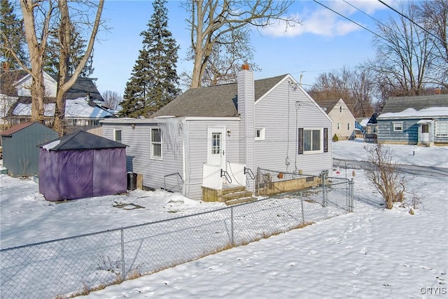 snow covered property with a storage shed