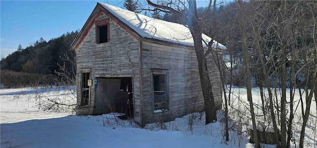 snow covered property featuring an outbuilding