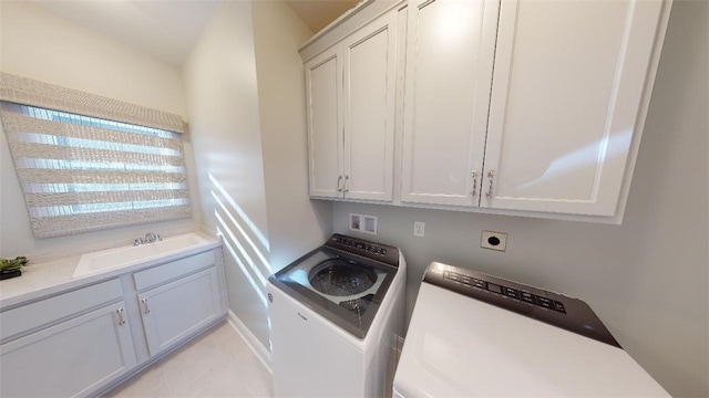 washroom featuring light tile patterned flooring, cabinets, sink, and washing machine and dryer