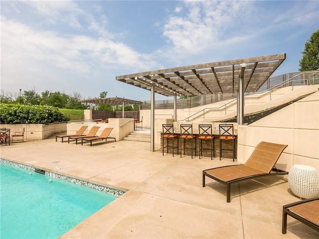 view of swimming pool featuring a patio, a pergola, and an outdoor bar