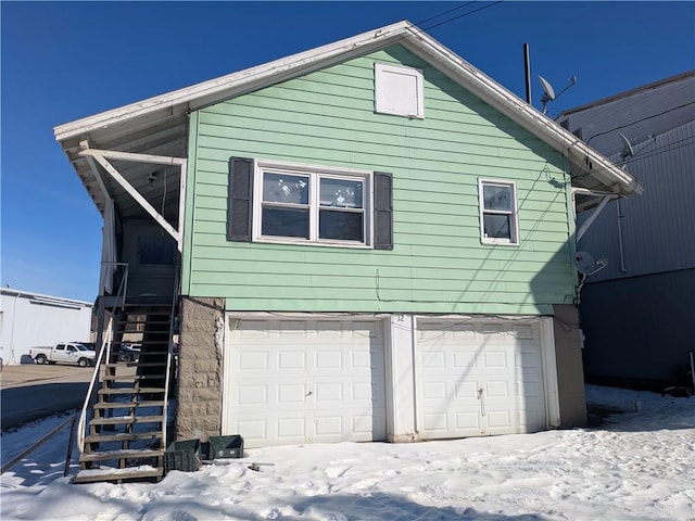 snow covered property featuring a garage