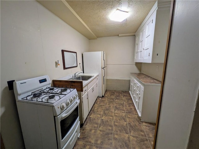 kitchen with white appliances, sink, a textured ceiling, and white cabinets