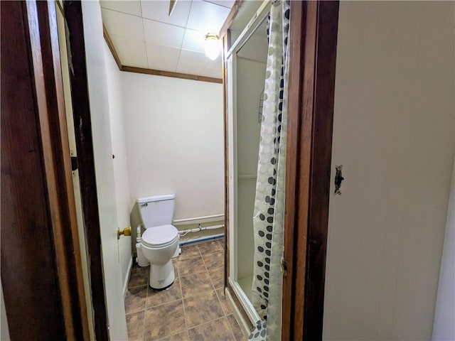 bathroom with a shower with door, crown molding, and toilet