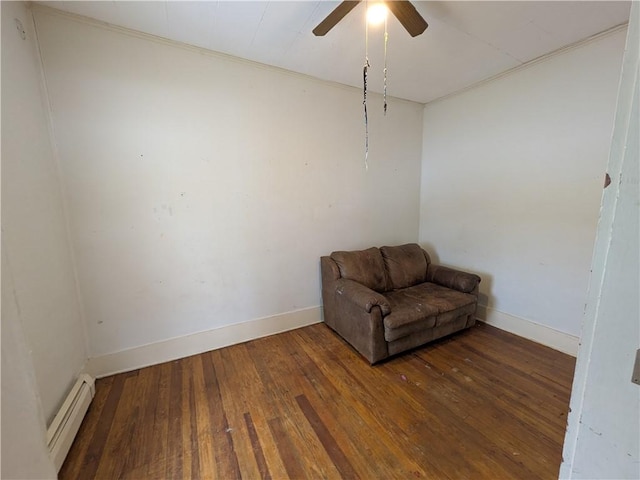 unfurnished room with ceiling fan, a baseboard heating unit, and dark hardwood / wood-style flooring