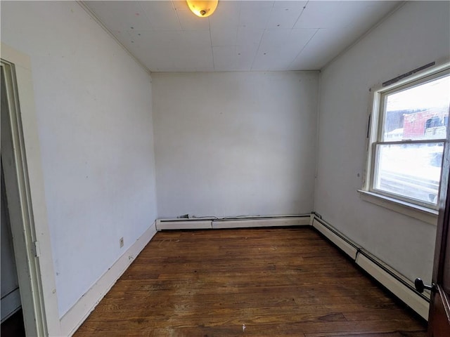 empty room with a baseboard radiator and dark hardwood / wood-style floors