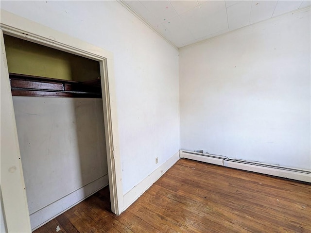 unfurnished bedroom with lofted ceiling, dark wood-type flooring, and baseboard heating