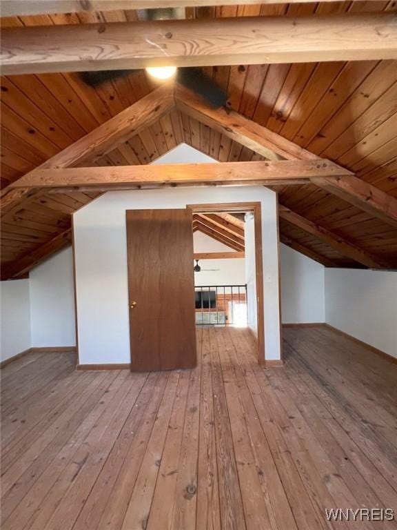 additional living space with light hardwood / wood-style flooring, lofted ceiling with beams, and wooden ceiling