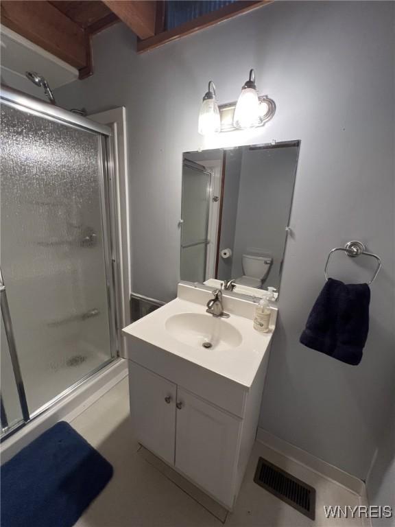 bathroom featuring vanity, tile patterned flooring, toilet, and walk in shower