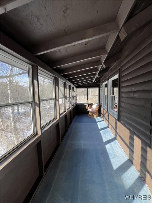 unfurnished sunroom featuring beamed ceiling