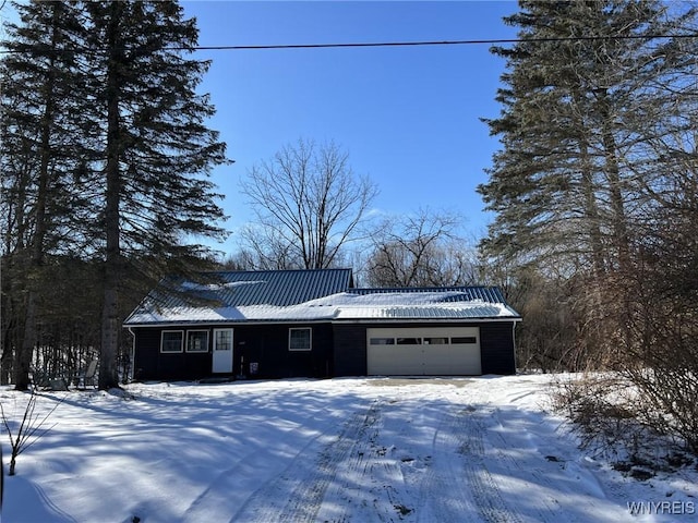 single story home with a garage and metal roof