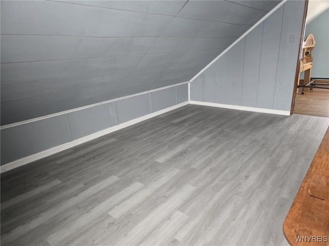 bonus room with hardwood / wood-style flooring and lofted ceiling