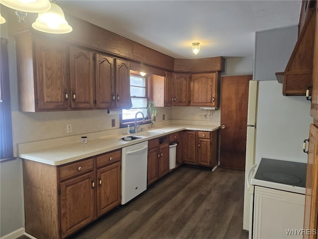 kitchen featuring white appliances, dark hardwood / wood-style flooring, and sink