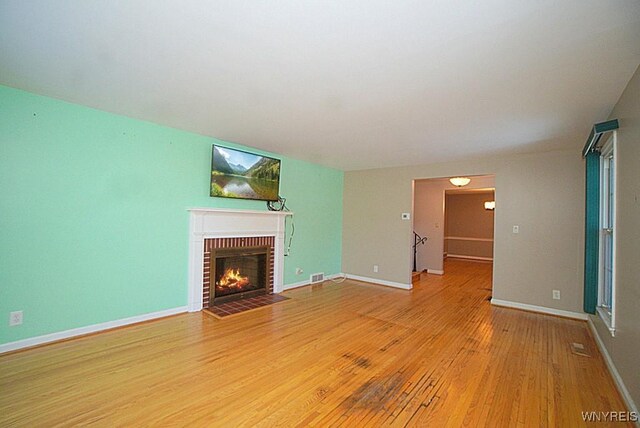 unfurnished living room with a fireplace and light hardwood / wood-style flooring