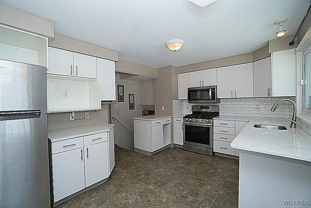 kitchen featuring stainless steel appliances, white cabinetry, and sink