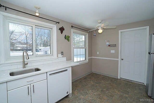 kitchen featuring white cabinetry, dishwasher, sink, white fridge, and ceiling fan