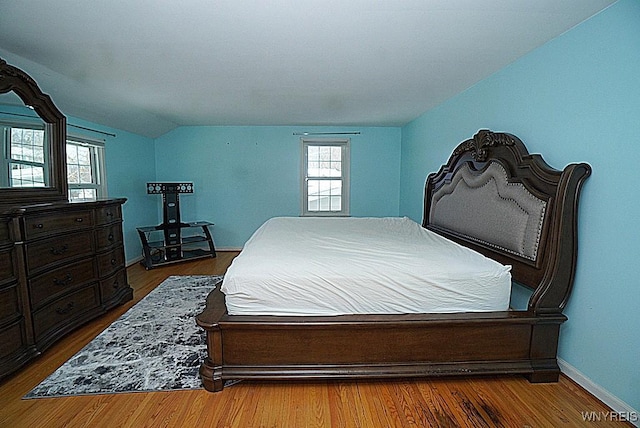 bedroom with vaulted ceiling and hardwood / wood-style floors