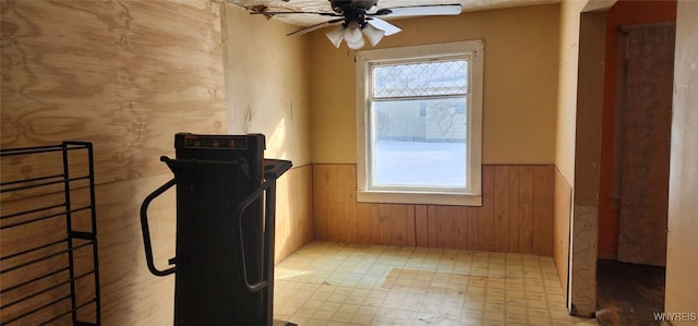 interior space featuring a healthy amount of sunlight, ceiling fan, and wood walls