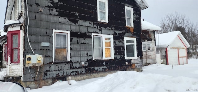 view of snowy exterior featuring an outbuilding