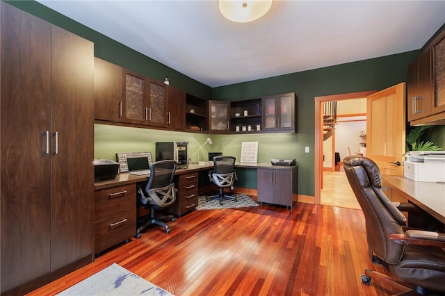 office area with dark hardwood / wood-style flooring and built in desk