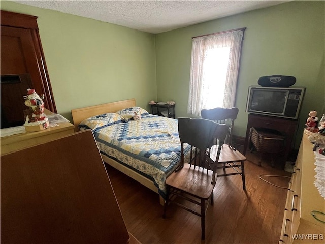 bedroom with hardwood / wood-style flooring and a textured ceiling