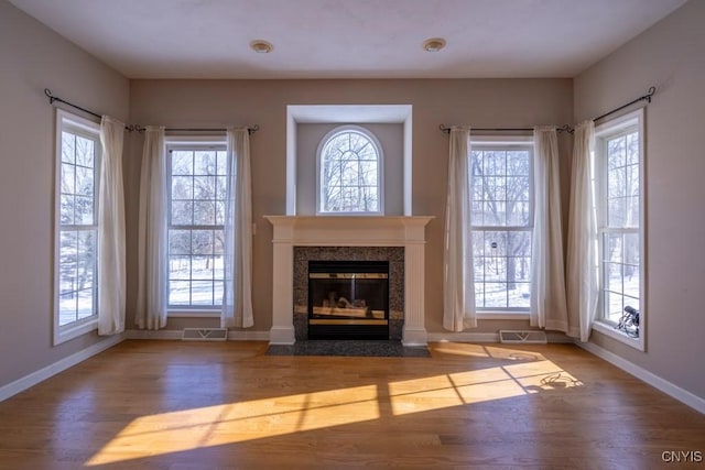 unfurnished living room featuring hardwood / wood-style floors and a high end fireplace