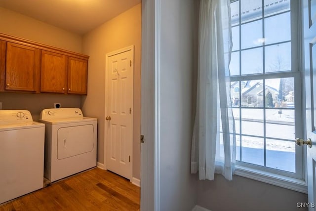 laundry area featuring cabinets, wood-type flooring, and washer and dryer