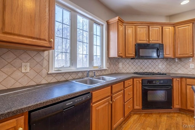 kitchen featuring light wood-type flooring, plenty of natural light, sink, and black appliances