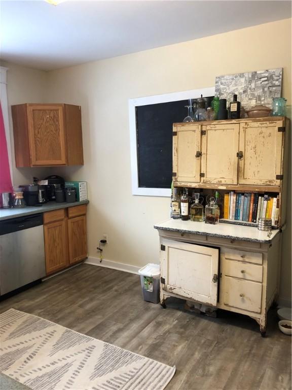 kitchen featuring dark wood-type flooring and stainless steel dishwasher