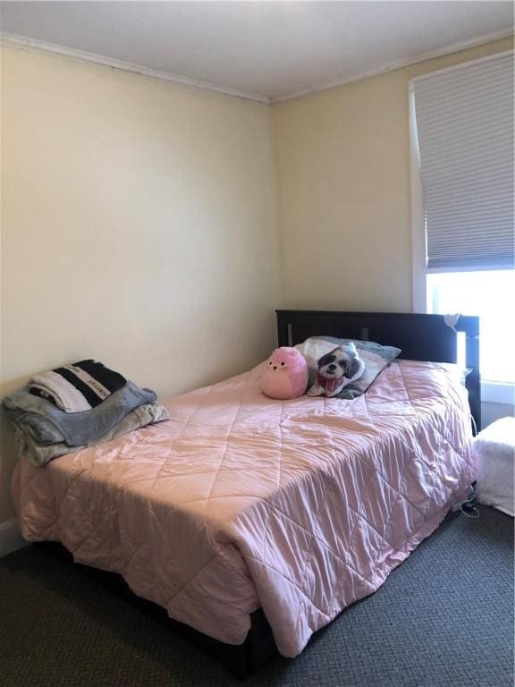 bedroom with crown molding and carpet floors