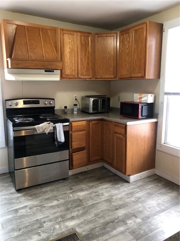 kitchen featuring light wood-type flooring and stainless steel electric range