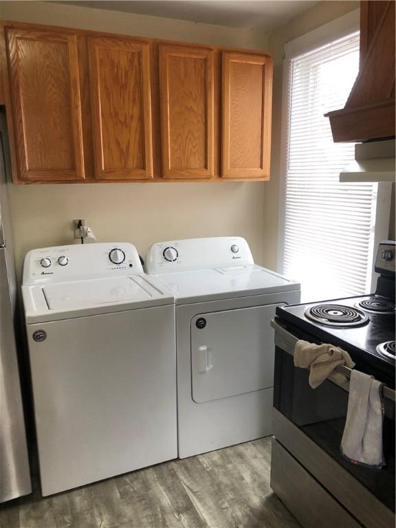 washroom with washer and clothes dryer and light hardwood / wood-style flooring