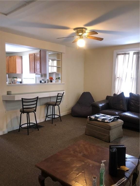 living room with ceiling fan and dark colored carpet