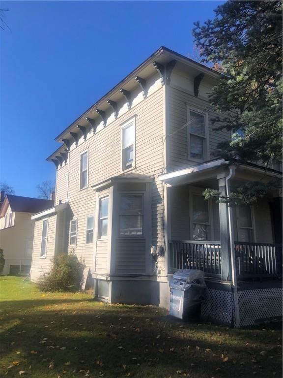 view of side of home featuring a lawn and a porch