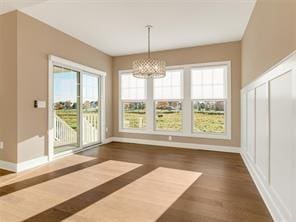 unfurnished dining area featuring dark hardwood / wood-style flooring and an inviting chandelier