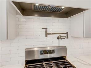 kitchen with stove and custom range hood