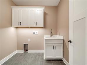 laundry room with hookup for a washing machine, electric dryer hookup, sink, and cabinets