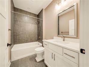 full bathroom featuring vanity, tiled shower / bath combo, and toilet