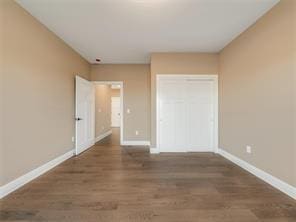 unfurnished bedroom with dark wood-type flooring