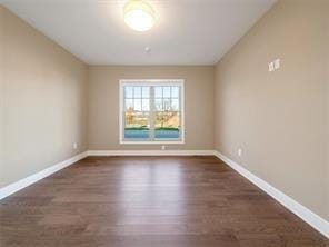 empty room with dark hardwood / wood-style flooring