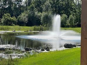 exterior space with a water view and a lawn