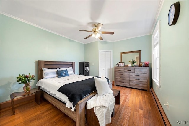 bedroom with crown molding, ceiling fan, a closet, and light hardwood / wood-style flooring