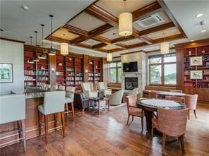 dining space with coffered ceiling, beam ceiling, and hardwood / wood-style flooring