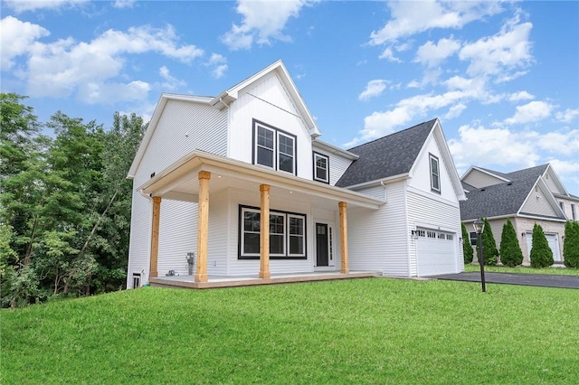 view of front facade featuring a garage, a front yard, and covered porch