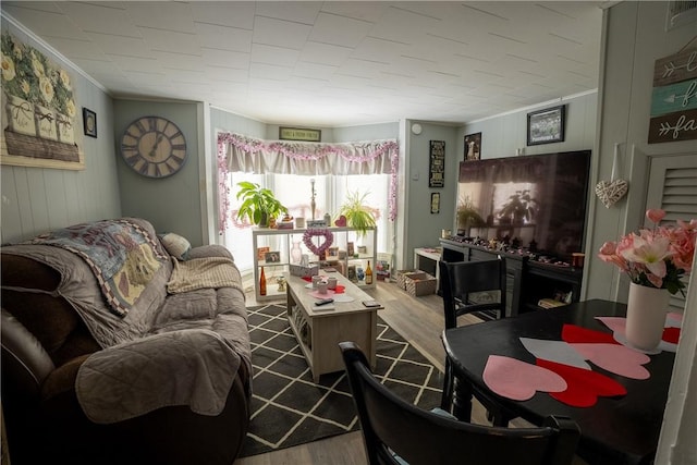 living room with crown molding and hardwood / wood-style floors