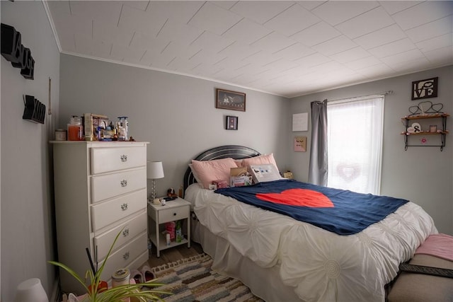 bedroom with ornamental molding and wood-type flooring